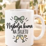 Bijela šalica za kumu s natpisom Najbolja kuma na svijetu i zelenom mašnom